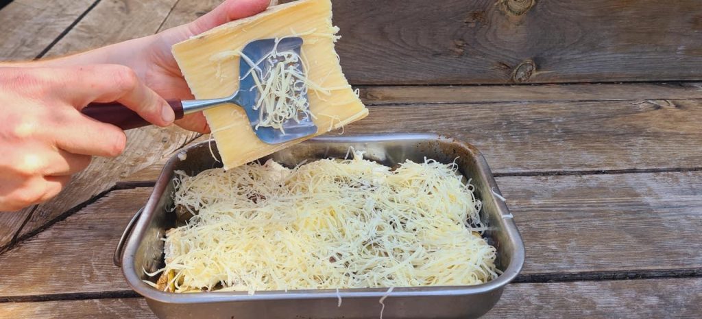Ajout du fromage râpé sur le hachis parmentier avant cuisson